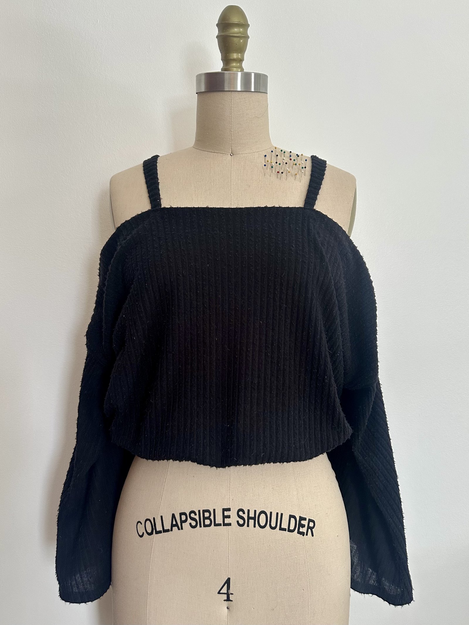 Black collapsible-shoulder boucle crop on dress form
