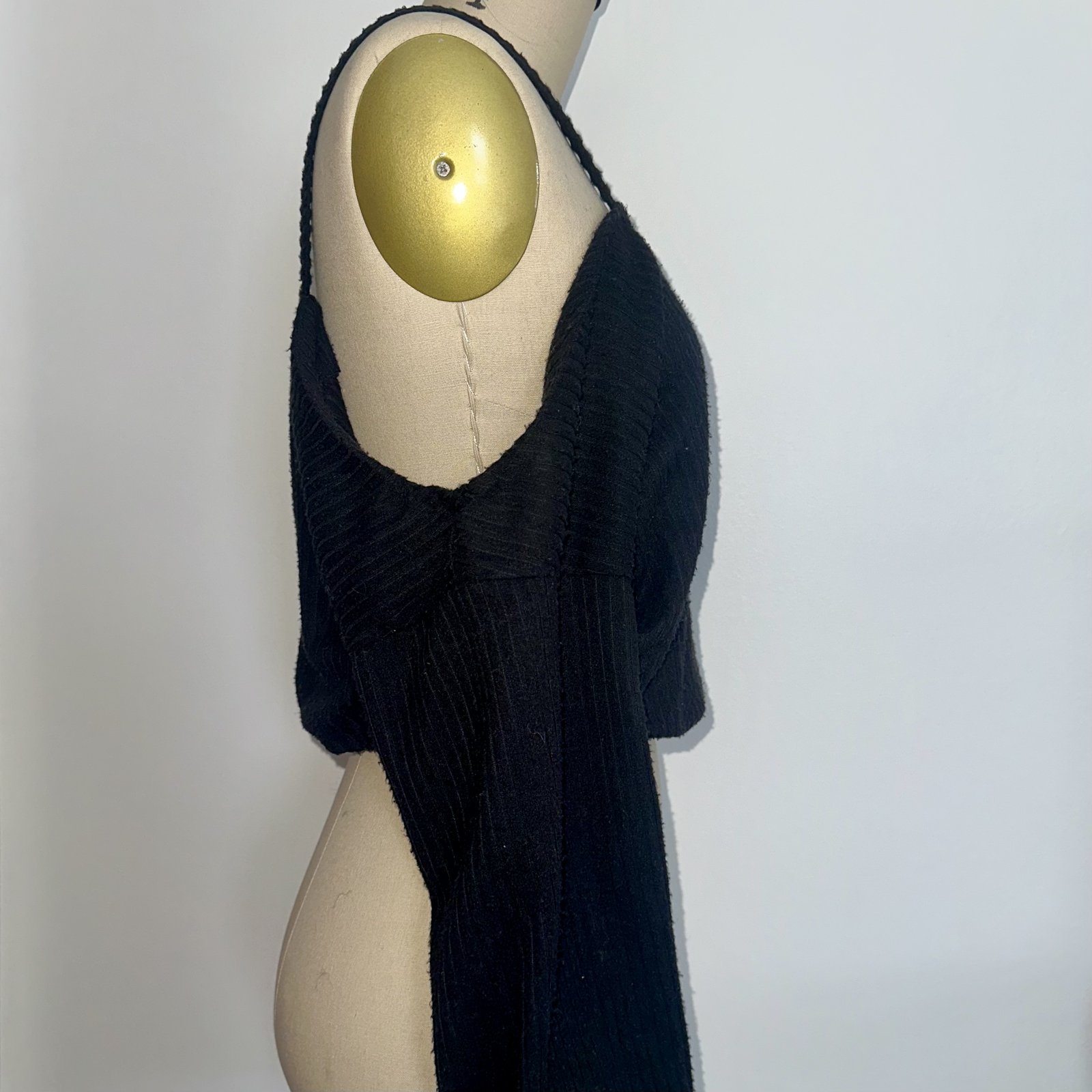 Profile of a black boucle crop with off-shoulder construction