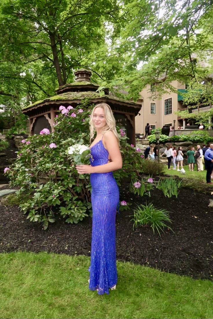 Royal blue beaded prom gown by Magen Jae in a garden