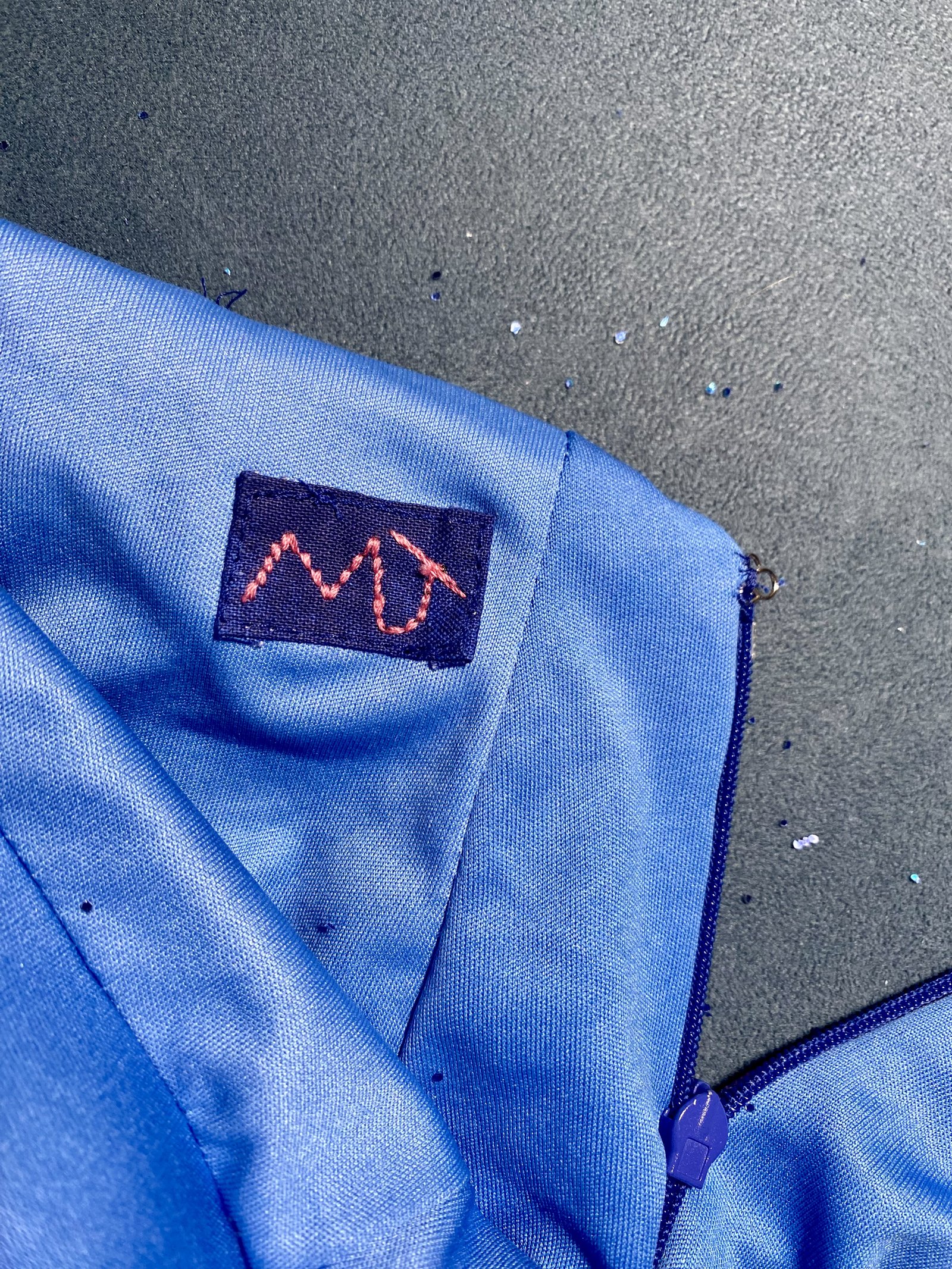 Hand-stitched M-J brand label on the inside of a couture eveningwear piece